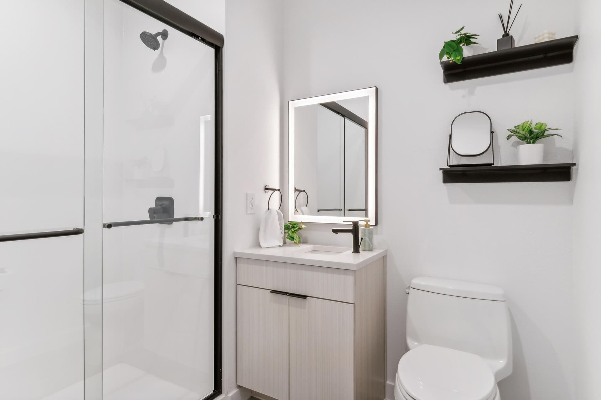Designer bathroom with glass shower and LED-lit mirror at Capitol Living