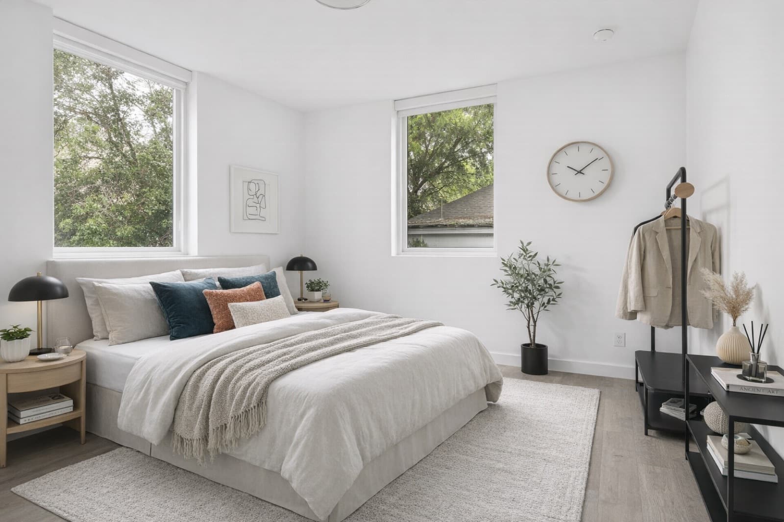 Corner bedroom with dual windows, navy pillows, and natural light at Capitol Living